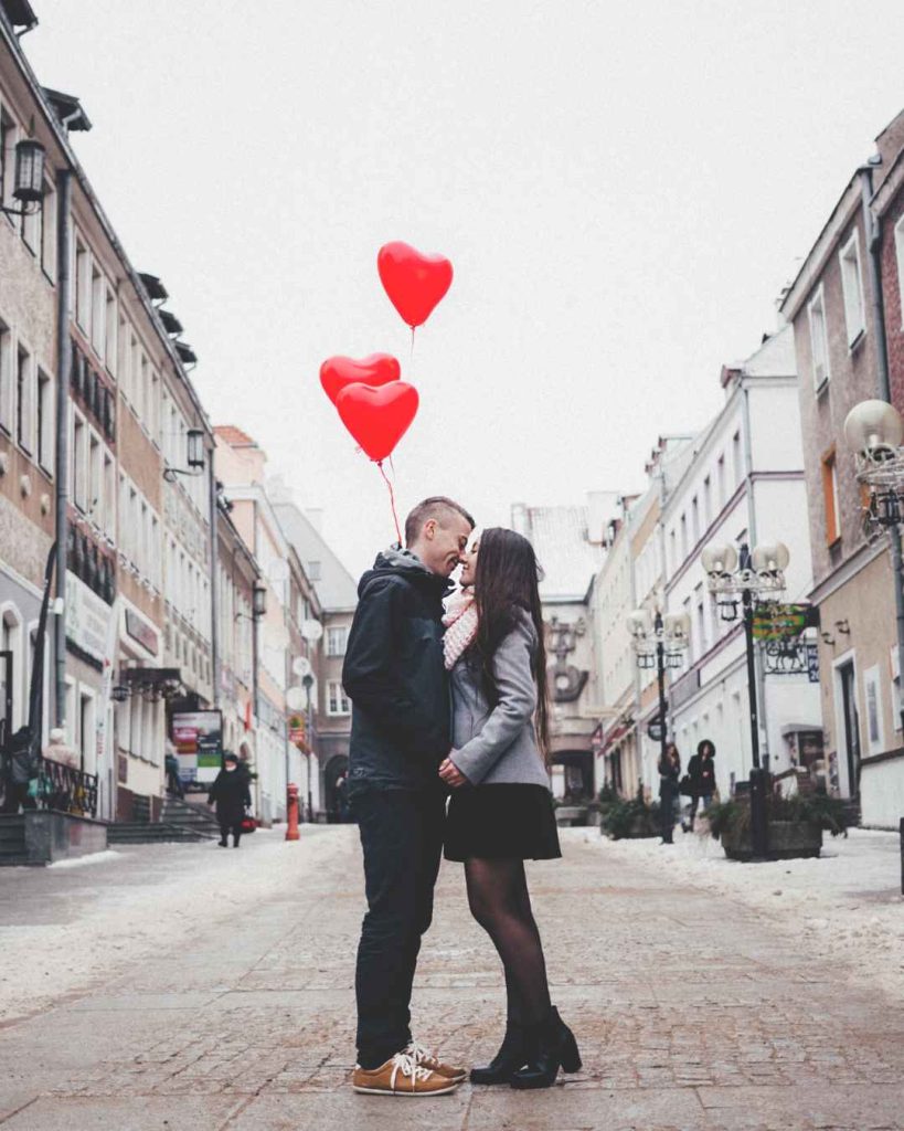 Casal com balões se beijando